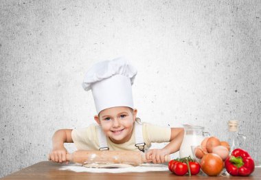 Hamuru uzatan una bulanmış küçük, mutlu bir aşçı.