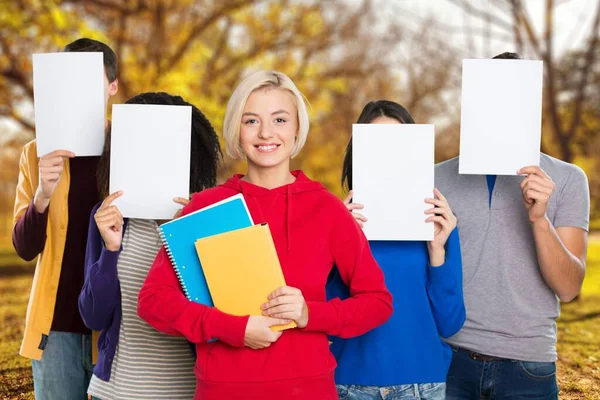 Kobieta Stojąca Przed Przyjaciółmi Trzymając Papier Pytaniami Znaki Towarowe — Zdjęcie stockowe