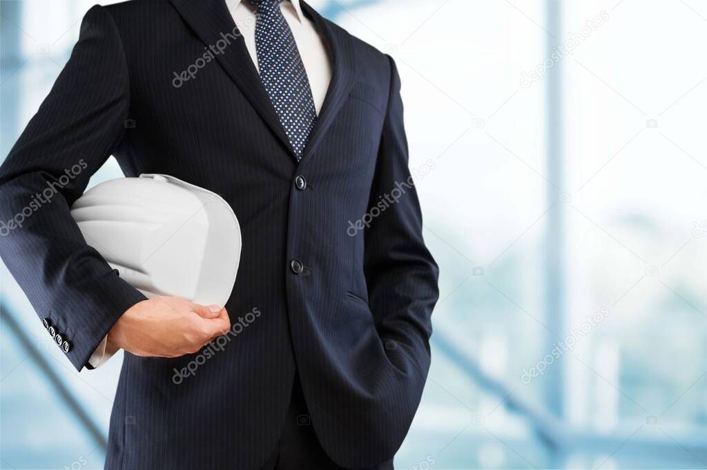 engineer yellow helmet for workers security on the background of a new high-rise apartment buildings and construction cranes and evening sunset sky