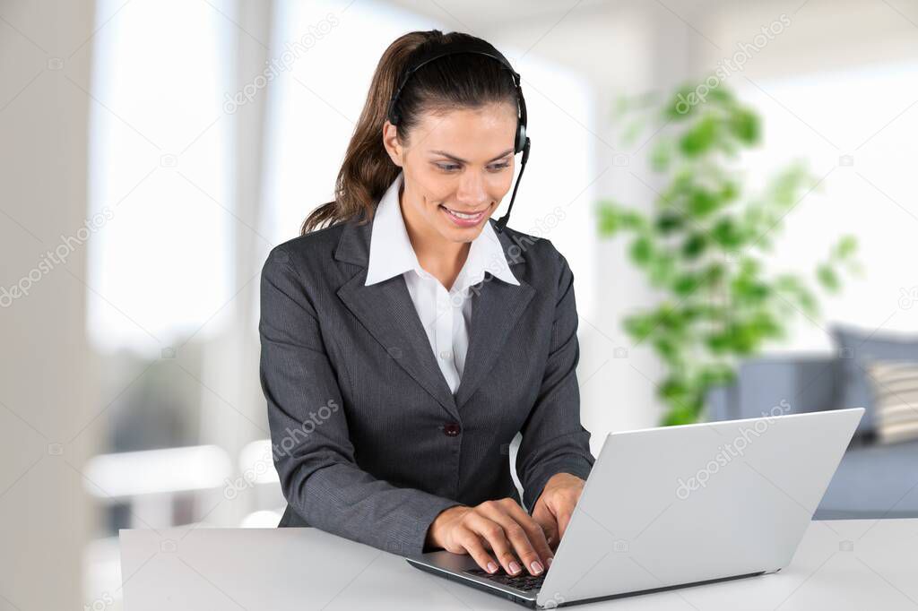 Focused girl wearing headset writing notes in notebook