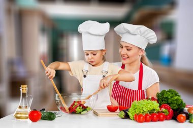 Mutlu anne, kızına nasıl salata yapılacağını öğretiyor.