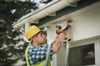 İşçi kamerasını açık hava CCTV Kurulum Sihirbazı konseptine yerleştirdi. CCTV kameraları yükleme servisi.