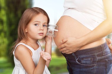 Hamile bir anne ve kızı tarlada çalışıyor.