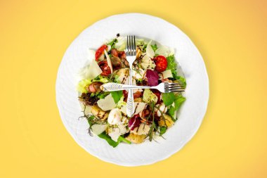 Çelik çatallar salata tabağının üstünde. Sağlıklı gıda konsepti