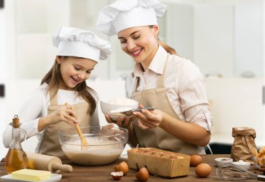 Neşeli mutlu anne kızına yemek yapmayı öğretiyor.