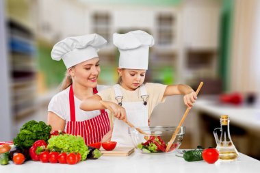 Mutlu anne, kızına nasıl salata yapılacağını öğretiyor.