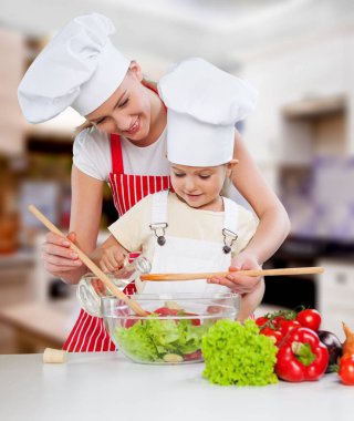 Mutlu anne, kızına nasıl salata yapılacağını öğretiyor.