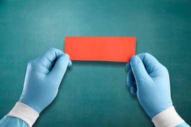 Tıbbi sembol. Doktor eli bir kart tutuyor. Güzel mavi arkaplan.