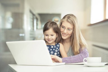 Küçük çocuğuyla mutlu bir anne online alışverişte ya da evde çalışıyor..