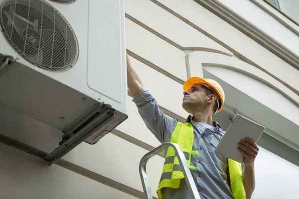 技術者の労働者は エアコン技術者と新しいエアコンをインストールする準備の一部を修復します 新しいエアコンをチェックする技術者 — ストック写真