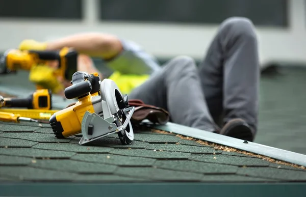 戴防护手套的屋顶工人 在正在施工的住宅楼新屋顶上使用或建造电动工具 — 图库照片