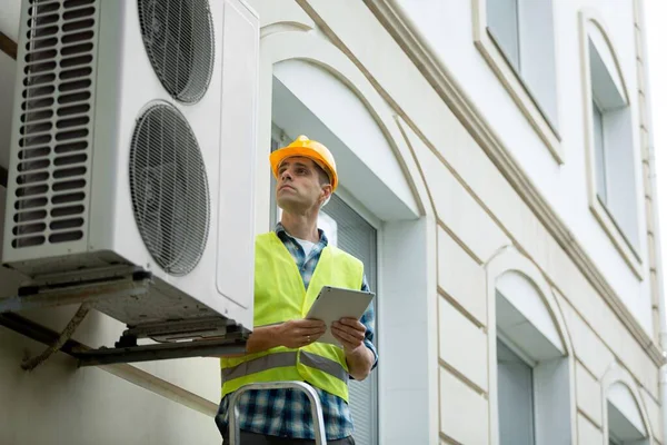 Technician worker repair Air Conditioning Technician and A part of preparing to install new air conditioner. Technician checking new air conditioner