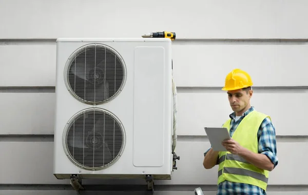 技術者の労働者は エアコン技術者と新しいエアコンをインストールする準備の一部を修復します 新しいエアコンをチェックする技術者 — ストック写真