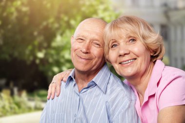 Park arka planında poz veren güzel bir yaşlı çiftin portresi.