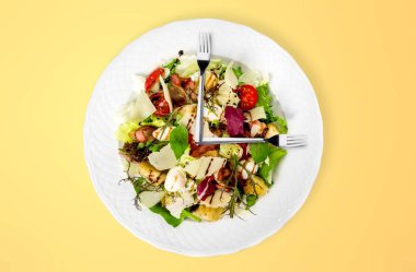 Çelik çatallar salata tabağının üstünde. Sağlıklı gıda konsepti