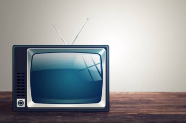 Arka plandaki ahşap masada antika eski televizyon.