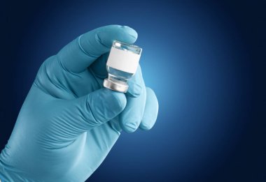 Doktor ya da hemşire ellerinde Coronavirus aşısı şişesi var..