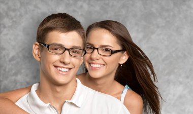 Gülümseyen güzel kadın ve yakışıklı erkek arkadaşı, duvarın yanında şefkatli anlar yaşıyorlar..