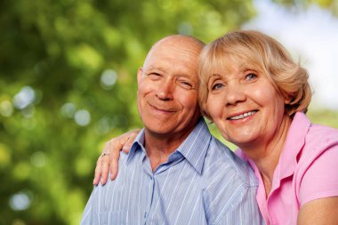 Park arka planında poz veren güzel yaşlı çiftin portresi.