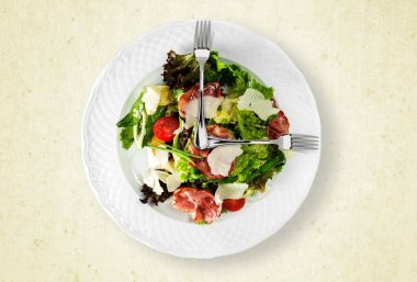 Çelik çatallar salata tabağının üstünde. Sağlıklı gıda konsepti