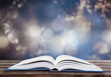 Tahta masanın üzerinde parıltılı kaplamalı sihirli bir antik kitap.