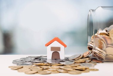 Mülk gayrimenkul ve ticari finansal konsept olarak kullanılan madeni paraların üzerindeki mini ev