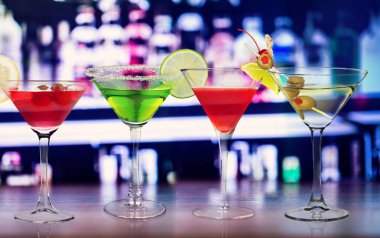 Renkli uzun içecekler çeşitli şekillerde ve gözlüklerle süslenmiş klasik bir kokteyl gibi..