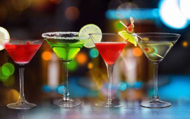 Renkli uzun içecekler çeşitli şekillerde ve gözlüklerle süslenmiş klasik bir kokteyl gibi..
