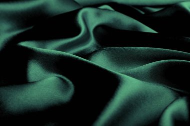 Doku, zümrüt yeşili yumuşak ipek kumaşın arka planı.
