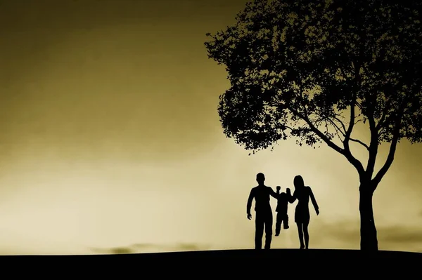 在落日的余晖下 快乐的父母抱着孩子在草地上玩耍 — 图库照片