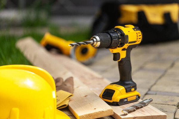 Строительные столярные инструменты электрические шнуровая циркулярная пила беспроводной дрель на заднем плане
