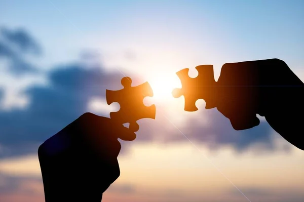 Pedaços Puzzle Conectando Com Mãos Fundo Céu Por Sol — Fotografia de Stock