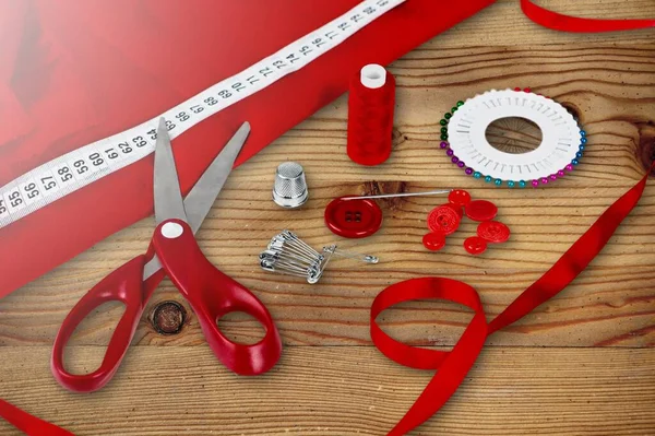 Premium Photo  Red, orange and green thread spool. scissors and seamstress  tape measure on a wooden background.