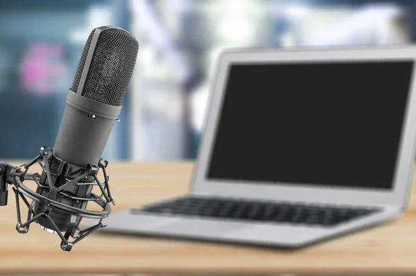 Home studio podcast interior. Microphone, laptop on the table.