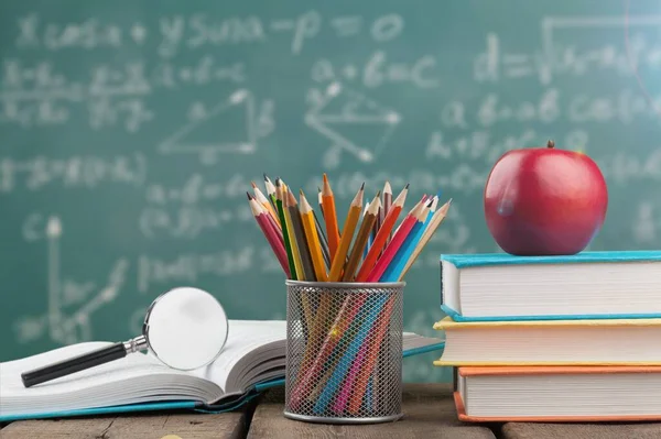 Ein Arbeitstisch Mit Büchern Bleistiften Und Äpfeln Auf Tafelwand — Stockfoto