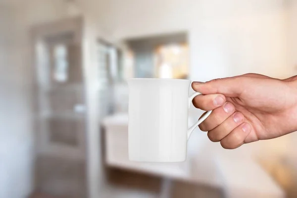 房间背景上女性手中的空陶瓷白咖啡杯或杯子 — 图库照片