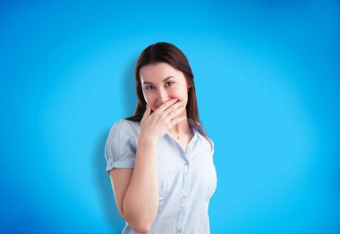 Neşeli gülümseyen, sıradan kıyafetler giyen genç bir kızın fotoğrafı.