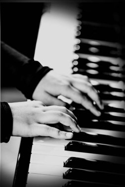 Piyanist, piyanisti klavyede müzik çalarken tutuyor. Müzik aleti anahtarları