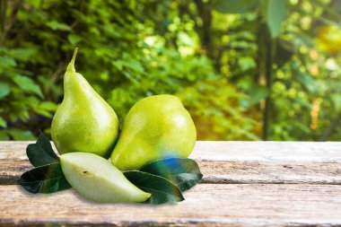 Masasında yaprak olan bir buçuk taze armut meyvesi.