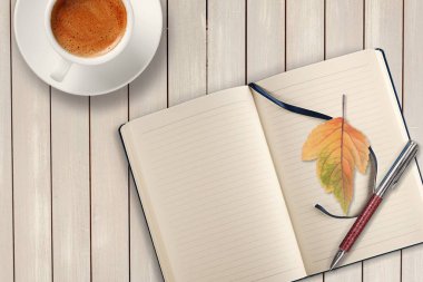 Boş bir günlük, bir bardak çayla birlikte ahşap bir masanın üzerinde şık bir kalemle, düş.