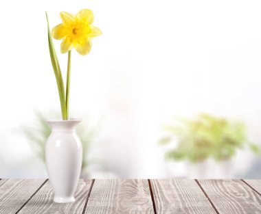 Masadaki beyaz cam vazoda bir buket taze çiçek.