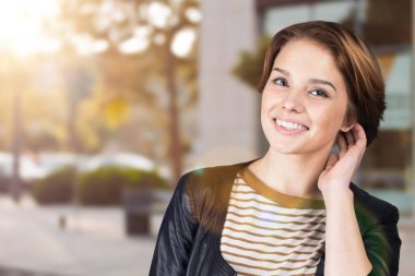 Güzel bir kadın gülümsüyor, rahatlamış ve mutlu duruyor.