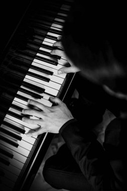 Piyanist, piyanisti klavyede müzik çalarken tutuyor. Müzik aleti anahtarları