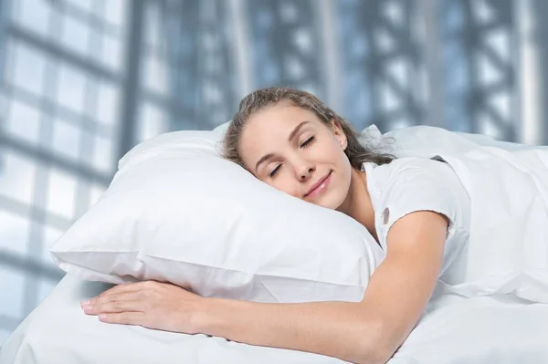 穿着睡衣睡在柔软床垫上的年轻女人 — 图库照片