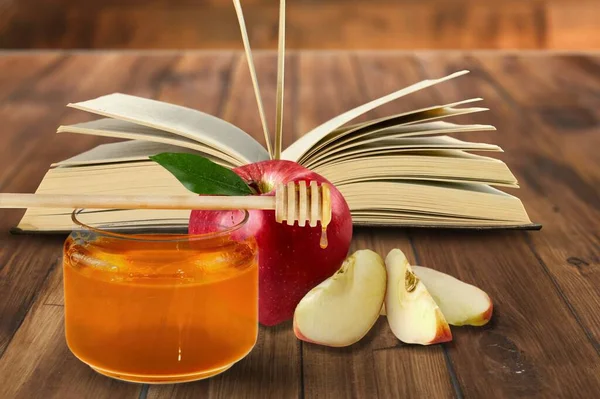 Red apples, honey and Torah book, Rosh Hashanah Jewish New Year holiday concept.