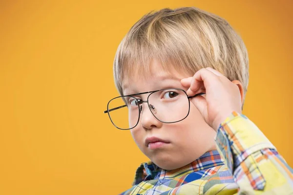 穿着绿色毛衣和眼镜的金发小男孩的画像 视力测试的孩子 时髦的孩子拿着眼镜 看着相机 学生视力测量 回学校去 — 图库照片