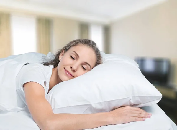 穿着睡衣睡在柔软床垫上的年轻女人 — 图库照片