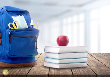 Şık bir sırt çantası ve ahşap masada farklı okul kırtasiyesi. Okula geri dön.