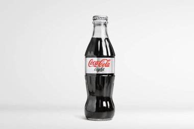 Soğuk klasik Coca-Cola şişesi beyaz masada.