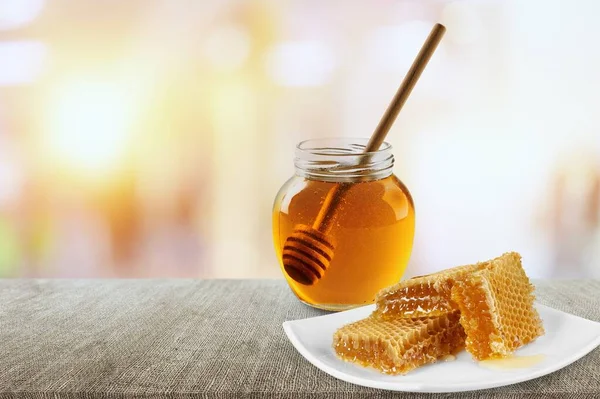 テーブルの上にディッパーが付いた瓶の中の蜂蜜 — ストック写真